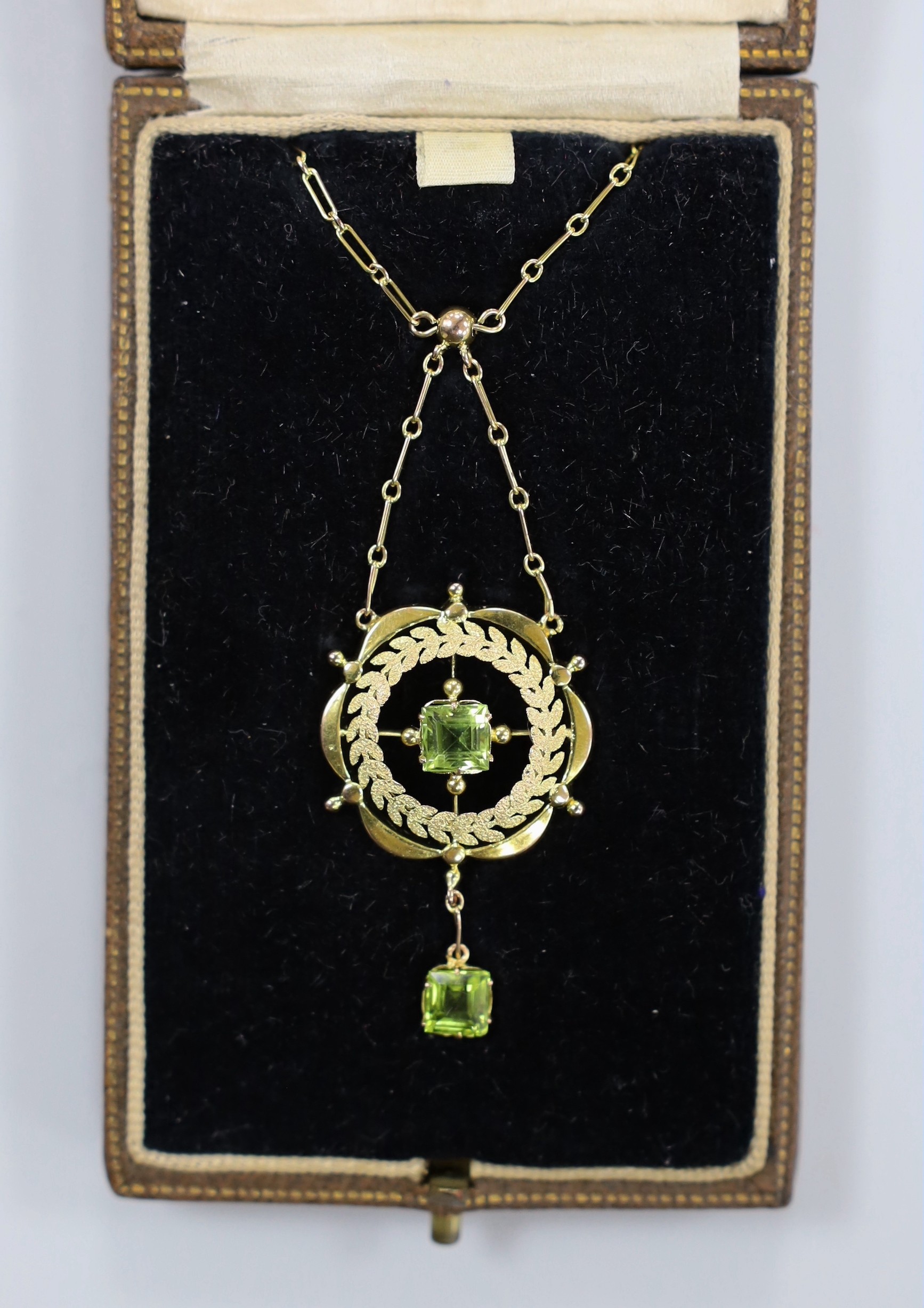 A 9ct and two stone peridot set drop pendant necklace, pendant 38mm, chain 43cm, gross weight 4.7 grams.